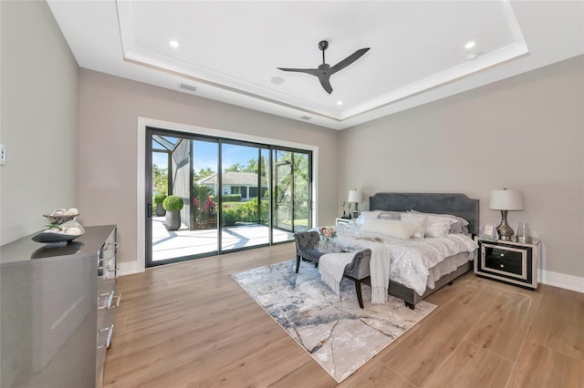 bedroom featuring recessed lighting, light wood finished floors, a raised ceiling, access to exterior, and visible vents