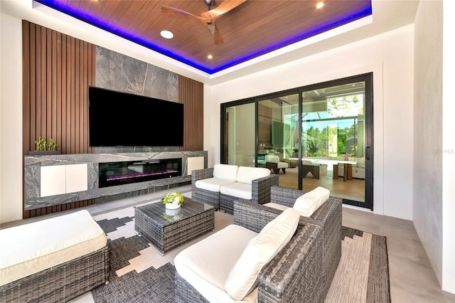 exterior space with recessed lighting, a raised ceiling, wooden ceiling, a fireplace, and ceiling fan