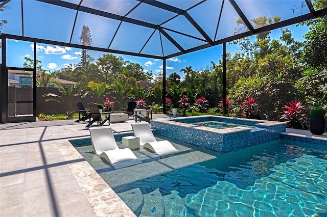 view of swimming pool featuring a patio area, a lanai, and a pool with connected hot tub