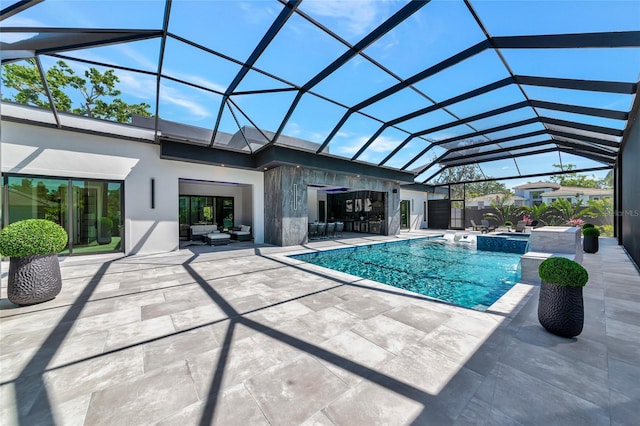 view of pool featuring a patio area, glass enclosure, a pool with connected hot tub, and a bar