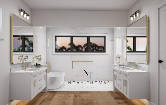 bathroom featuring a sink, a soaking tub, and two vanities