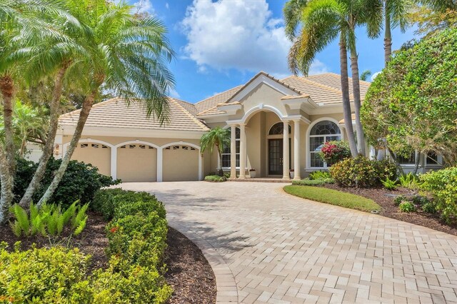 7011 Portmarnock Pl, Lakewood Ranch, FL 34202 - mediterranean / spanish house with a garage, stucco siding, decorative driveway, and a tiled roof