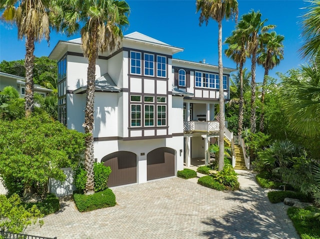 103 Park Ave, Anna Maria, FL 34216 - view of front of home with a garage, stairway, stucco siding, and decorative driveway