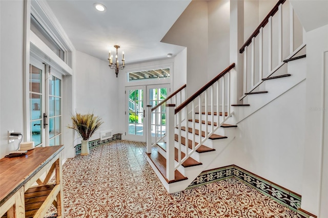 103 Park Ave, Anna Maria, FL 34216 - foyer featuring a chandelier, stairway, baseboards, and french doors