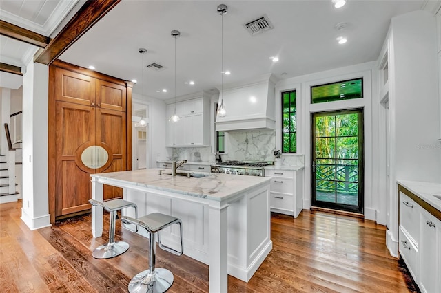 103 Park Ave, Anna Maria, FL 34216 - kitchen with a kitchen breakfast bar, visible vents, backsplash, and custom range hood