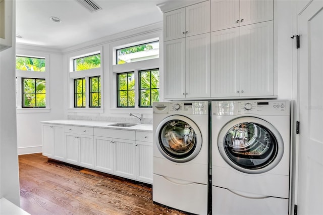 103 Park Ave, Anna Maria, FL 34216 - laundry room with wood finished floors, visible vents, a sink, independent washer and dryer, and cabinet space