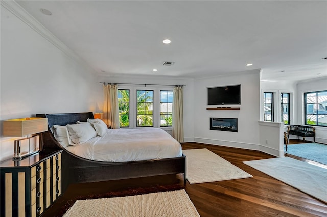 103 Park Ave, Anna Maria, FL 34216 - bedroom with a glass covered fireplace, visible vents, recessed lighting, wood finished floors, and crown molding
