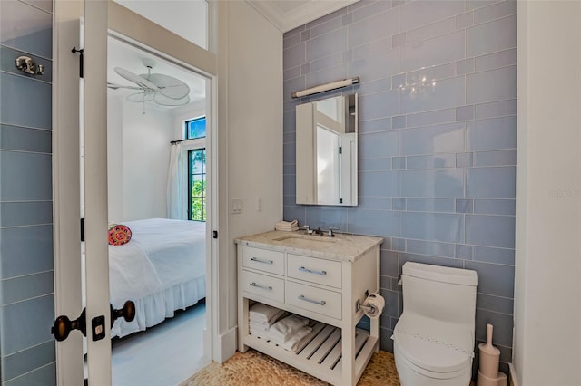 103 Park Ave, Anna Maria, FL 34216 - bathroom with connected bathroom, vanity, tile walls, ceiling fan, and toilet