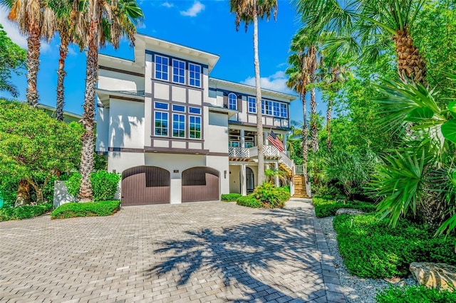 103 Park Ave, Anna Maria, FL 34216 - view of front facade featuring a garage, stairs, a balcony, stucco siding, and decorative driveway