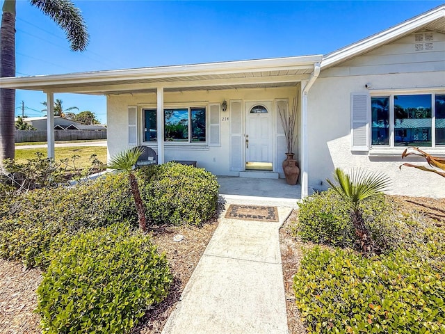 214 49th St W, Bradenton, FL 34209 - doorway to property with a porch, fence, and stucco siding