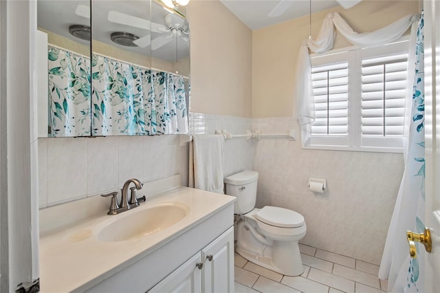 214 49th St W, Bradenton, FL 34209 - full bath with curtained shower, tile patterned flooring, toilet, vanity, and tile walls
