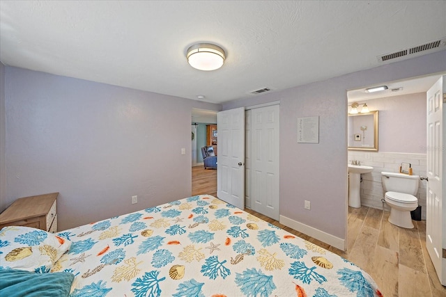 130 E Seminole Dr, Venice, FL 34293 - bedroom with visible vents, a closet, ensuite bathroom, and light wood-style flooring