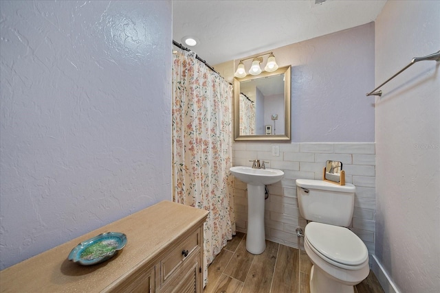 130 E Seminole Dr, Venice, FL 34293 - full bath with toilet, wood finished floors, a shower with curtain, and tile walls