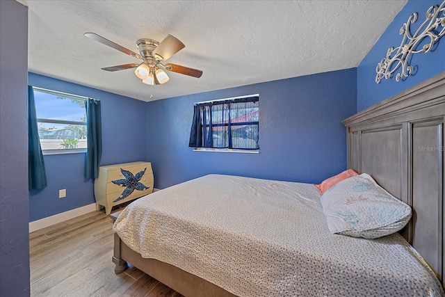 130 E Seminole Dr, Venice, FL 34293 - bedroom with a textured ceiling, wood finished floors, ceiling fan, and baseboards