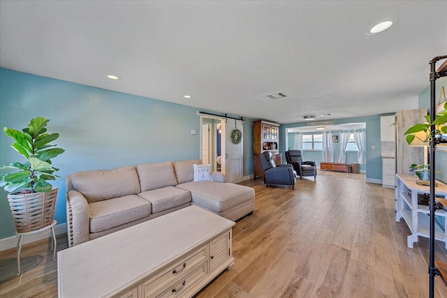 130 E Seminole Dr, Venice, FL 34293 - living room with baseboards, recessed lighting, a barn door, light wood-style floors, and visible vents