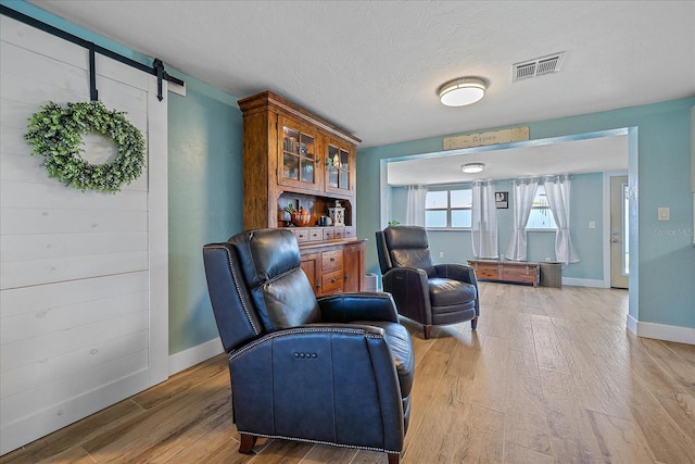 130 E Seminole Dr, Venice, FL 34293 - sitting room featuring visible vents, baseboards, light wood finished floors, and a barn door