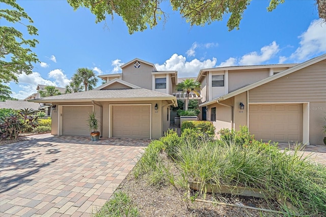 1612 Starling Dr Unit 101, Sarasota, FL 34231 - view of front facade with a garage, stucco siding, and decorative driveway