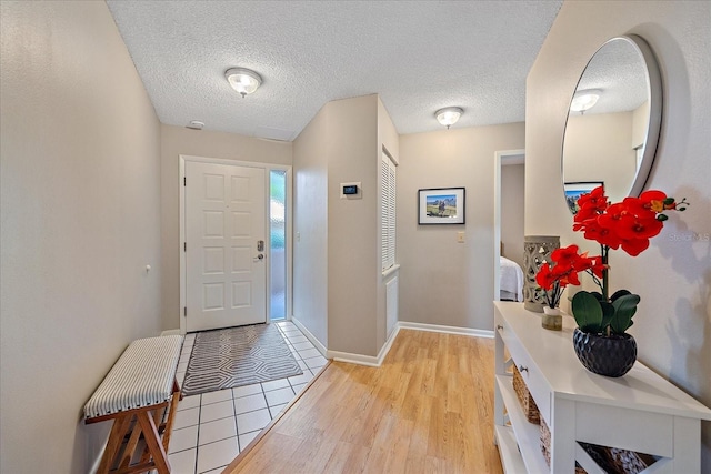 1612 Starling Dr Unit 101, Sarasota, FL 34231 - foyer entrance featuring a textured ceiling, light wood finished floors, and baseboards