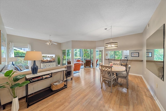 1612 Starling Dr Unit 101, Sarasota, FL 34231 - dining area with baseboards, a textured ceiling, visible vents, ceiling fan with notable chandelier, and wood finished floors
