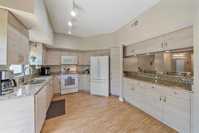 1612 Starling Dr Unit 101, Sarasota, FL 34231 - kitchen featuring visible vents, a sink, white appliances, light wood-style floors, and light stone counters