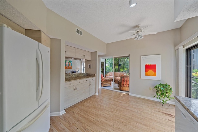 1612 Starling Dr Unit 101, Sarasota, FL 34231 - kitchen with visible vents, baseboards, ceiling fan, freestanding refrigerator, and a textured ceiling