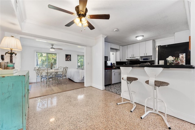 2307 Valencia Dr, Sarasota, FL 34239 - kitchen with a breakfast bar, dark countertops, dishwasher, baseboards, and ceiling fan