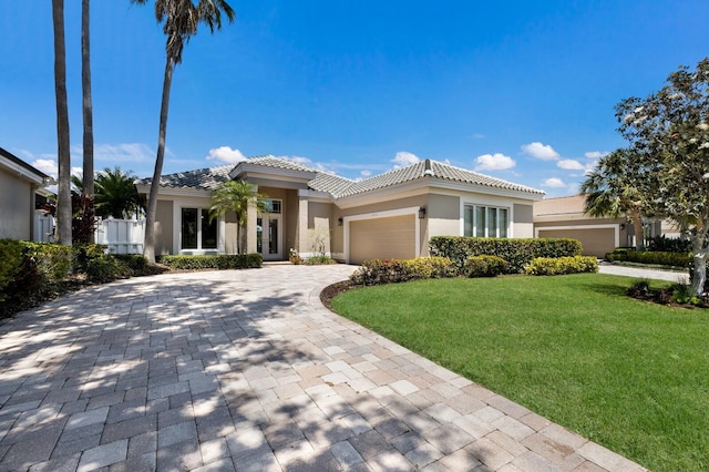 8715 52nd Ave E, Bradenton, FL 34211 - view of front facade with french doors, a front yard, an attached garage, and a tiled roof