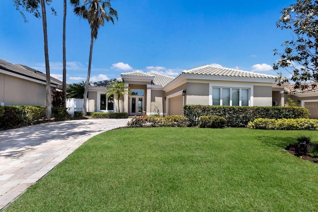 8715 52nd Ave E, Bradenton, FL 34211 - prairie-style home with an attached garage, a tiled roof, a front lawn, and decorative driveway