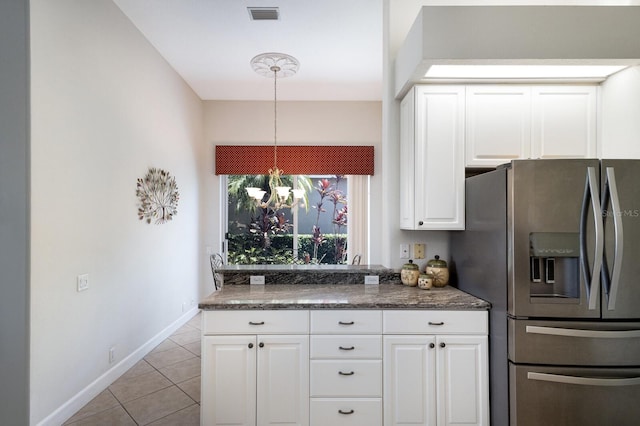 8715 52nd Ave E, Bradenton, FL 34211 - kitchen with stainless steel fridge, light tile patterned floors, white cabinetry, hanging light fixtures, and a chandelier