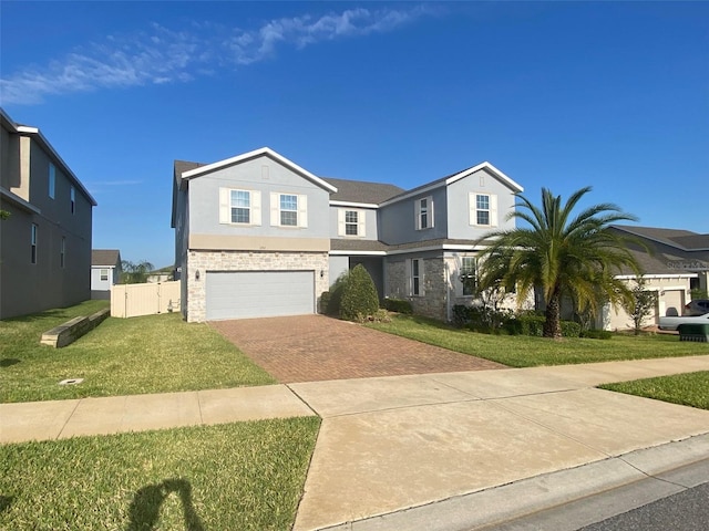 1142 Blarney St, Minneola, FL 34715 - traditional home featuring stucco siding, decorative driveway, stone siding, a front lawn, and a garage