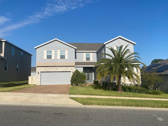 1142 Blarney St, Minneola, FL 34715 - traditional-style home with stucco siding, decorative driveway, a front yard, stone siding, and a garage