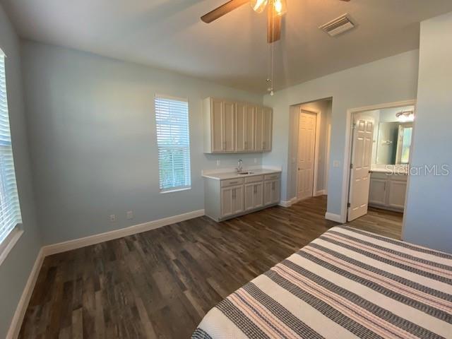 1142 Blarney St, Minneola, FL 34715 - interior space featuring dark wood finished floors, a ceiling fan, visible vents, a sink, and baseboards