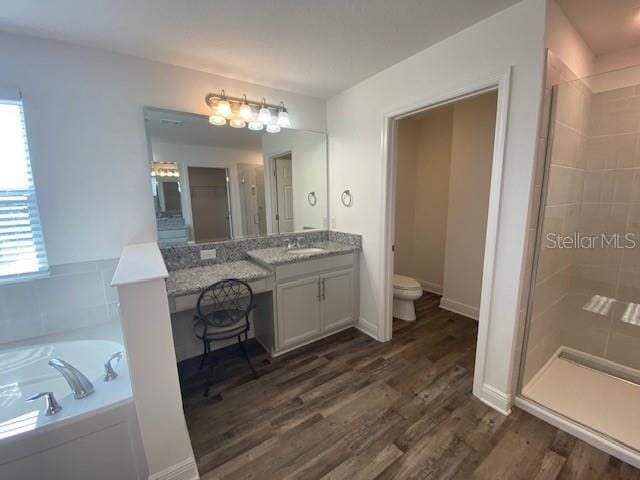 1142 Blarney St, Minneola, FL 34715 - full bathroom featuring a shower stall, a bath, vanity, toilet, and wood finished floors