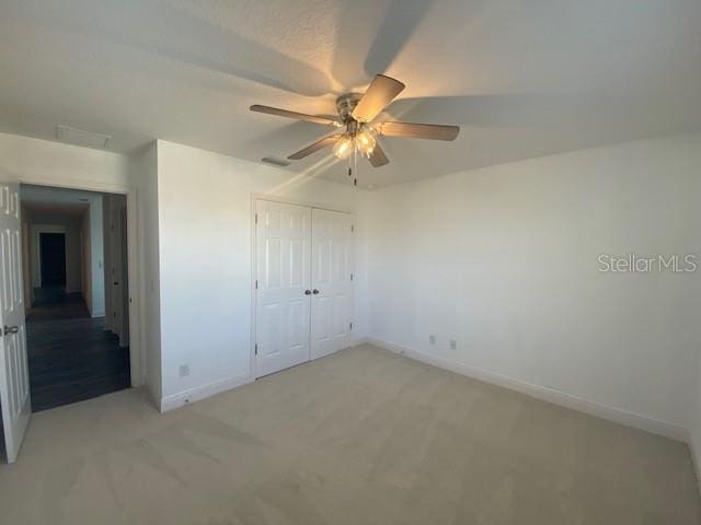 1142 Blarney St, Minneola, FL 34715 - unfurnished bedroom with a closet, light colored carpet, baseboards, and a ceiling fan