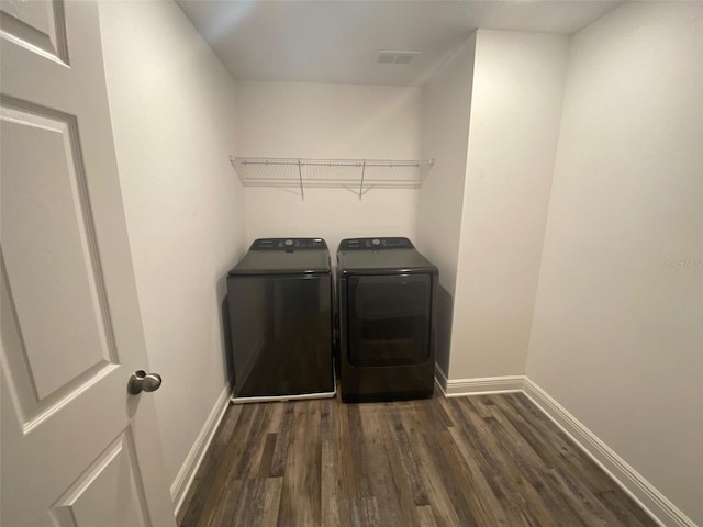 1142 Blarney St, Minneola, FL 34715 - washroom with baseboards, dark wood-type flooring, visible vents, washer and clothes dryer, and laundry area
