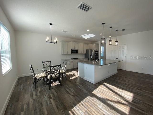 1142 Blarney St, Minneola, FL 34715 - kitchen with dark wood finished floors, visible vents, a kitchen island, stainless steel appliances, and baseboards