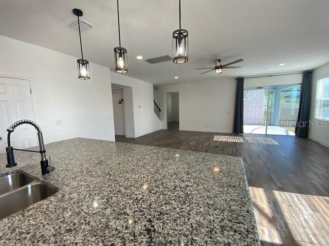 1142 Blarney St, Minneola, FL 34715 - kitchen featuring hanging light fixtures, a sink, dark wood-style flooring, ceiling fan, and stone countertops