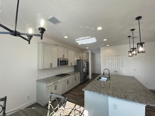 1142 Blarney St, Minneola, FL 34715 - kitchen with visible vents, a sink, appliances with stainless steel finishes, a kitchen island with sink, and recessed lighting