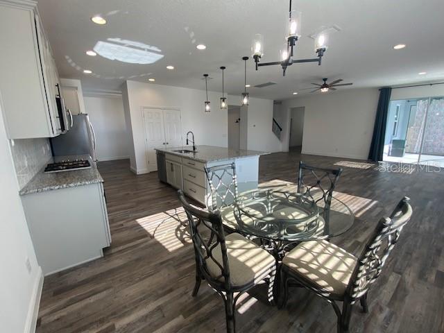1142 Blarney St, Minneola, FL 34715 - dining area featuring recessed lighting, dark wood-type flooring, baseboards, and ceiling fan with notable chandelier