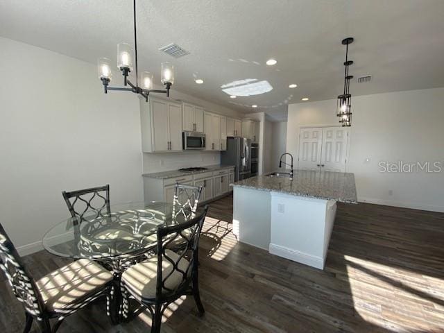 1142 Blarney St, Minneola, FL 34715 - kitchen featuring a sink, an island with sink, dark wood finished floors, recessed lighting, and stainless steel appliances