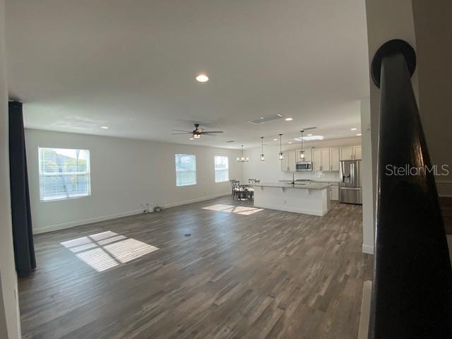 1142 Blarney St, Minneola, FL 34715 - unfurnished living room with dark wood-type flooring, baseboards, recessed lighting, and a ceiling fan