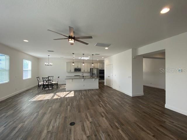 1142 Blarney St, Minneola, FL 34715 - living room with recessed lighting, dark wood-type flooring, baseboards, and ceiling fan with notable chandelier
