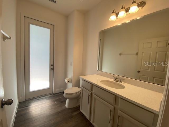 1142 Blarney St, Minneola, FL 34715 - bathroom featuring toilet, wood finished floors, vanity, and baseboards