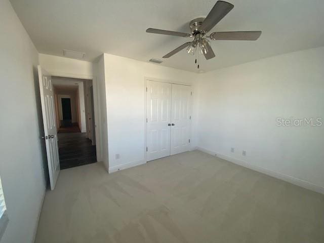 1142 Blarney St, Minneola, FL 34715 - unfurnished bedroom featuring visible vents, a closet, baseboards, attic access, and light colored carpet