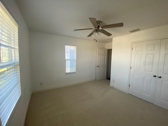 1142 Blarney St, Minneola, FL 34715 - unfurnished bedroom featuring a closet, light colored carpet, a ceiling fan, visible vents, and baseboards