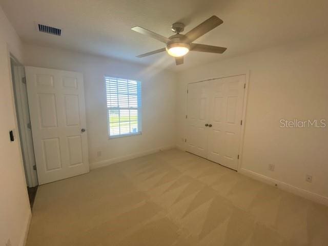 1142 Blarney St, Minneola, FL 34715 - unfurnished bedroom featuring light carpet, a closet, baseboards, and visible vents
