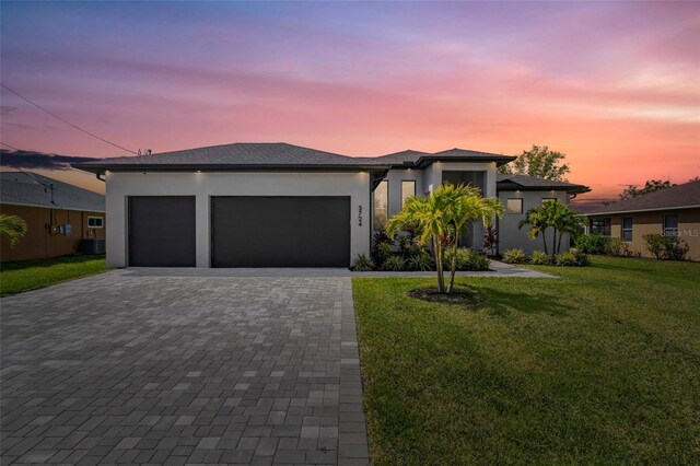 3724 SW 3rd St, Cape Coral, FL 33991 - prairie-style home with a garage, stucco siding, a front yard, and decorative driveway