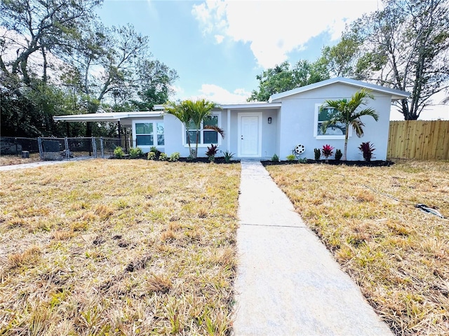 1142 Newhope Rd, Spring Hill, FL 34606 - view of front of property featuring fence, a front yard, a carport, and stucco siding