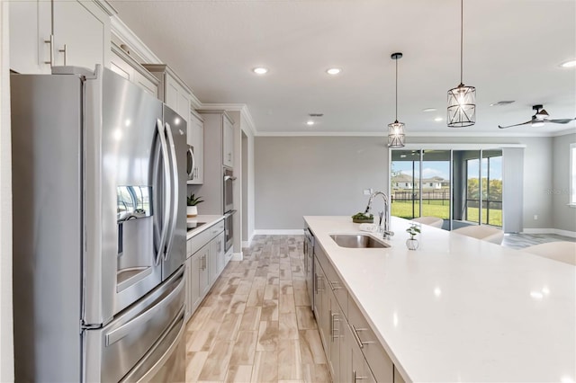 kitchen featuring a sink, stainless steel appliances, light countertops, recessed lighting, and ornamental molding
