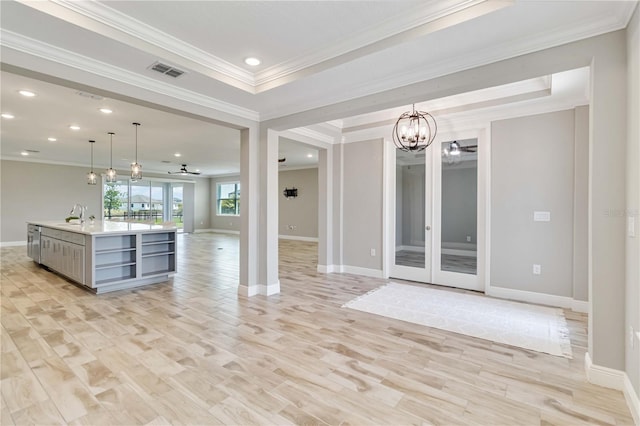 unfurnished living room featuring crown molding, a sink, and baseboards